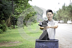 Volunteer collecting trash garbage, man holding and dumping garbage bag, clean up area of dirty, environmental charity concept