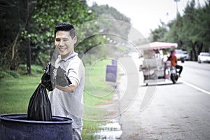 Volunteer collecting trash garbage, man holding and dumping garbage bag, clean up area of dirty, environmental charity concept