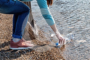 Volunteer collects garbage from the pond. Concept of preservation of ecology and environmental cleanliness