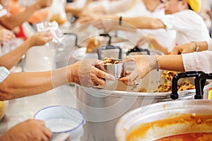 Volunteer food servers dish out a free charity : concept of helping