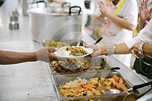 Volunteer food servers dish out a free charity : concept of helping