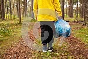 Volunteer hands picks up  plastic trash grass in park. Eco friendly