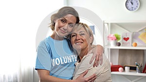 Volunteer hugging old lady, pensioners assistance, support program and charity
