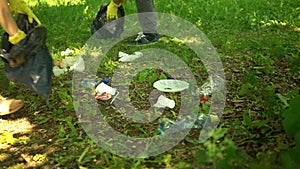 Volunteer scavenge plastic garbage in the summer park. Ecology concept