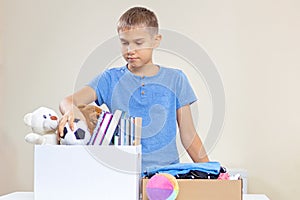 Volunteer sorting toys, clothes, books, donation goods in donate charity boxes on the table