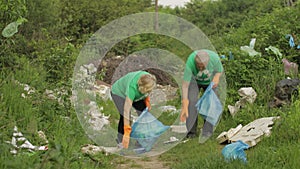 Volunteer team cleaning up dirty park from plastic bags, bottles. Reduce trash cellophane pollution