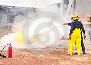 Volunteer using fire extinguisher from hose for fire fighting during basic fire fighting training evacuation