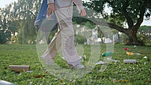 Volunteer walking park trash pollution. Conservationist girl stepping grass