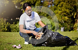 Volunteer, woman and cleaning waste in park for community service, pollution and climate change or earth day project