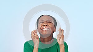 Volunteer woman, cross fingers and studio for hope, faith or luck for results by blue background. African girl