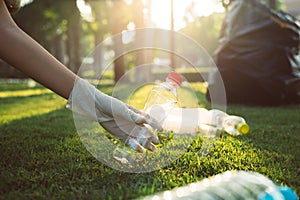 Volunteer woman hands keep plastic bottle on green grass,Good conscious mind,Dispose recycle and waste management concept