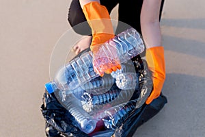 Volunteer woman holding black color garbage bag with keeping plastic bottle at beach,Dispose recycle and waste management concept,