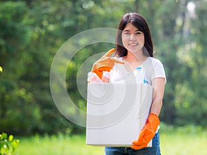 Volunteer women collect plastic water bottles in the park area