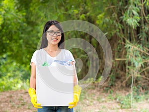 Volunteer women collect plastic water bottles in the park area