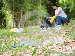 Volunteer women collect plastic water bottles in the park area