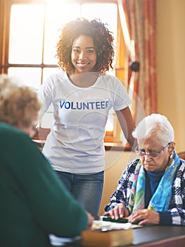 Volunteering is its own reward. a volunteer working with seniors at a retirement home.