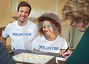 Volunteering is so rewarding. Portrait of volunteers working with seniors at a retirement home.