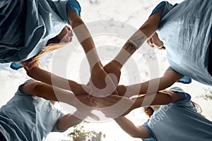 Volunteering. Young people volunteers outdoors standing hands together close-up bottom view teamwork