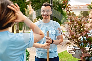 Volunteering. Young people volunteers standing outdoors boy close-up with shovel smiling cheerful planting