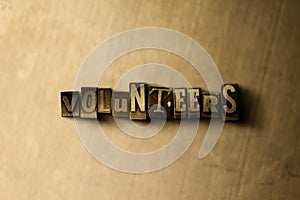 VOLUNTEERS - close-up of grungy vintage typeset word on metal backdrop photo