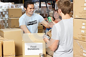 Volunteers Collecting Food Donations In Warehouse photo