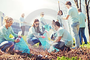 Volunteers with garbage bags cleaning park area