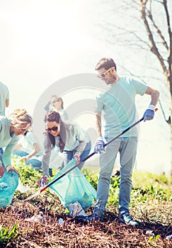 Volunteers with garbage bags cleaning park area