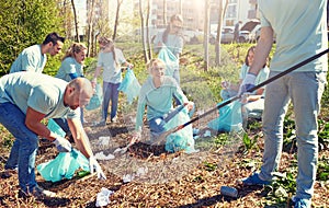 Volunteers with garbage bags cleaning park area