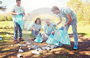 Volunteers with garbage bags cleaning park area