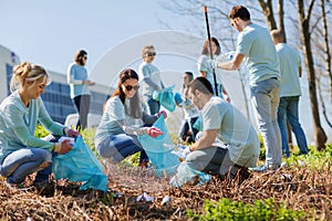 Volunteers with garbage bags cleaning park area