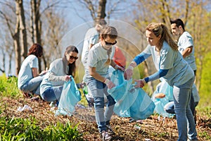 Volunteers with garbage bags cleaning park area