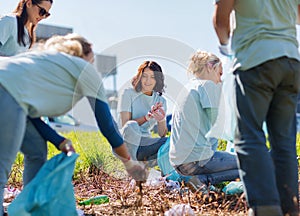 Volunteers with garbage bags cleaning park area