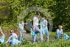 Volunteers with garbage bags cleaning park area