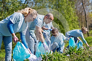 Volunteers with garbage bags cleaning park area