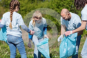 Volunteers with garbage bags cleaning park area