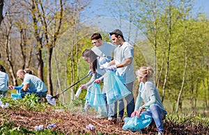 Volunteers with garbage bags cleaning park area