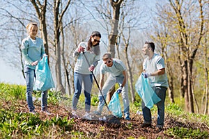 Volunteers with garbage bags cleaning park area