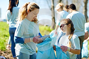 Volunteers with garbage bags cleaning park area