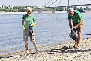 Volunteers gathering garbage on river bank. Ecology concept