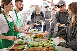 Volunteers giving food to poor people