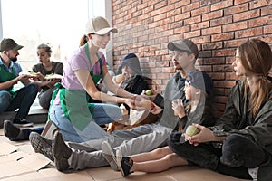 Volunteers giving food to poor people