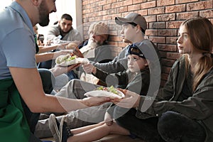 Volunteers giving food to poor people photo