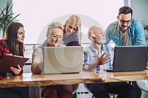 Volunteers help senior people on the computer