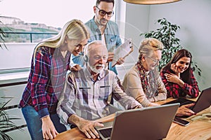 Volunteers help senior people on the computer