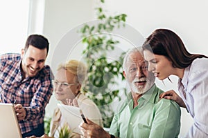 Volunteers help senior people on the computer. Young people giving senior people introduction to internet