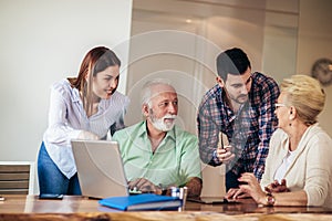 Volunteers help senior people on the computer. Young people giving senior people introduction to internet