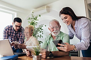 Volunteers help senior people on the computer. Young people giving senior people introduction to internet