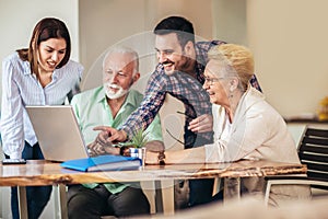 Volunteers help senior people on the computer. Young people giving senior people introduction to internet