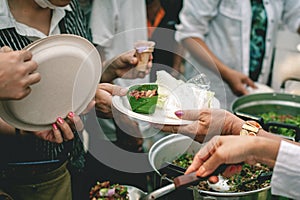 Volunteers are helping to give free food to the hungry homeless : food service and food donation concept