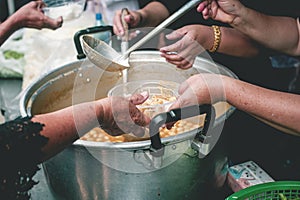 Volunteers are helping to give free food to the hungry homeless : food service and food donation concept